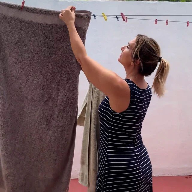 Vrouw hangt op een warme dag de was op zonder aan haar BH te trekken